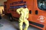 Mold removal tech standing by work van