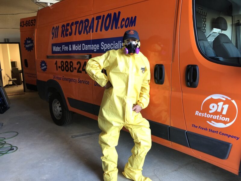 Mold removal tech standing by work van